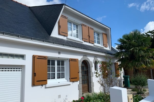 Maison blanche de style breton avec volets battants brun clair en composite Yzé
