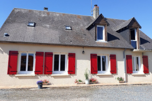 Maison traditionnelle avec volets battants rouges en composite Yzéa installés sur façade claire