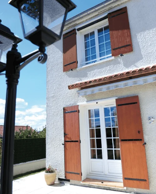 Façade de maison équipée de volets battants en composite imitation bois Yzéa