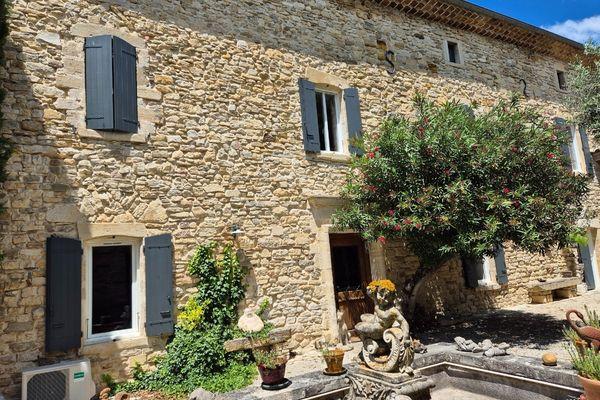 Maison ancienne en pierre avec volets battants gris sur une façade traditionnelle