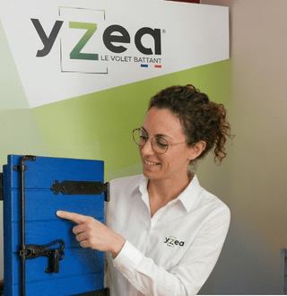 Présentation d’un volet battant en composite Yzéa avec démonstration des ferrures par une collaboratrice